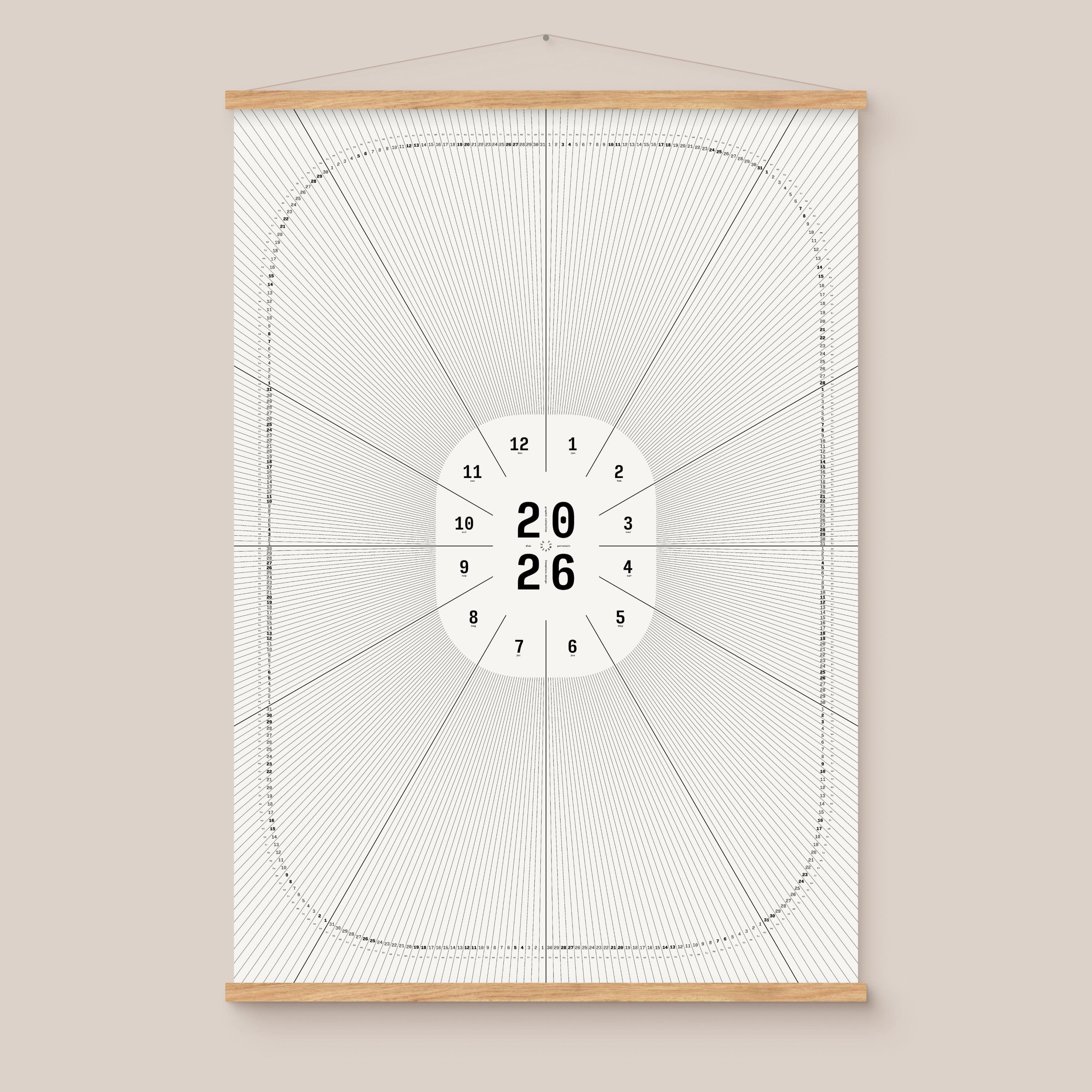 Framed geometric calendar with a circular design and numbers on a beige wall, natural wooden hanger frame