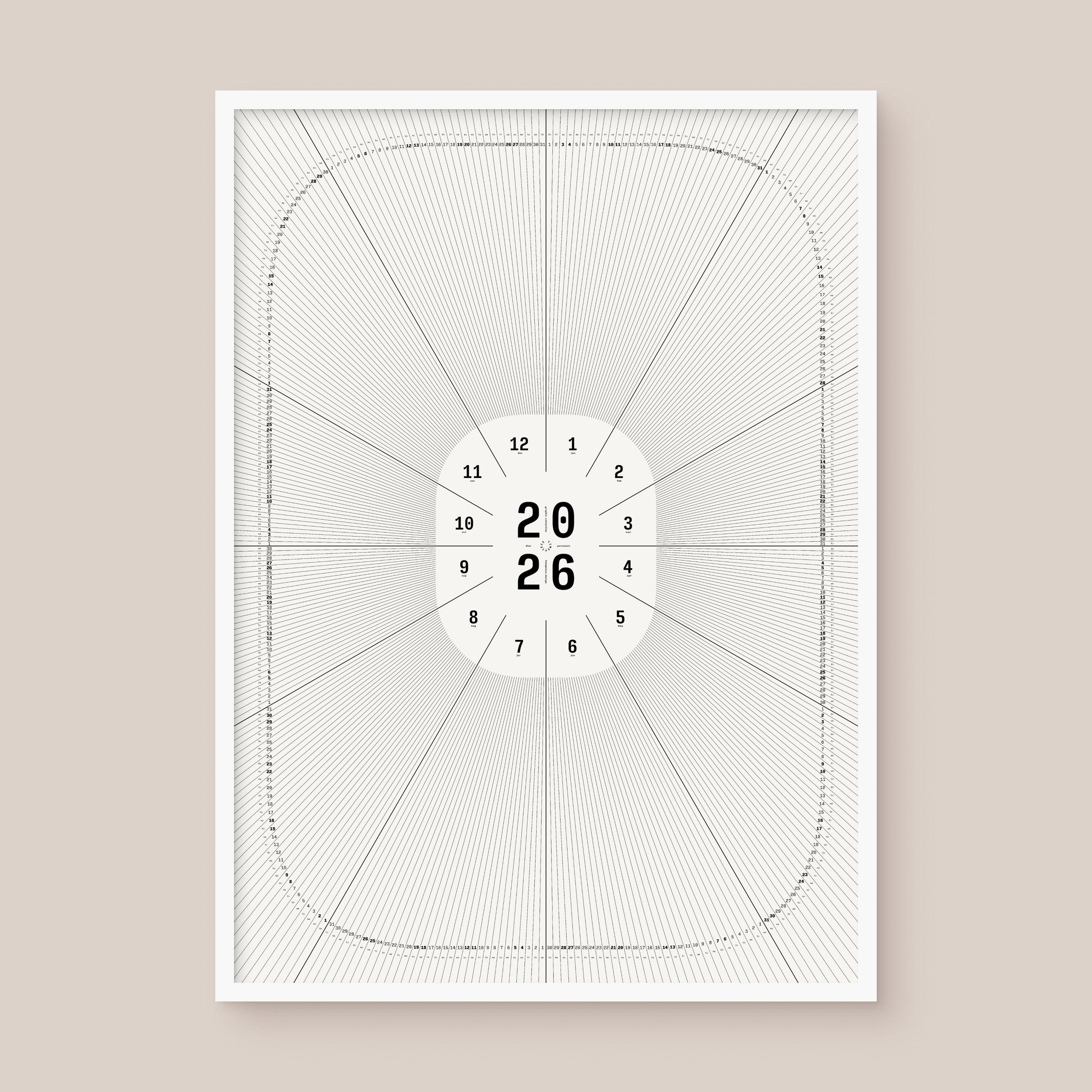 Framed geometric calendar with a circular design and numbers on a beige wall, white frame