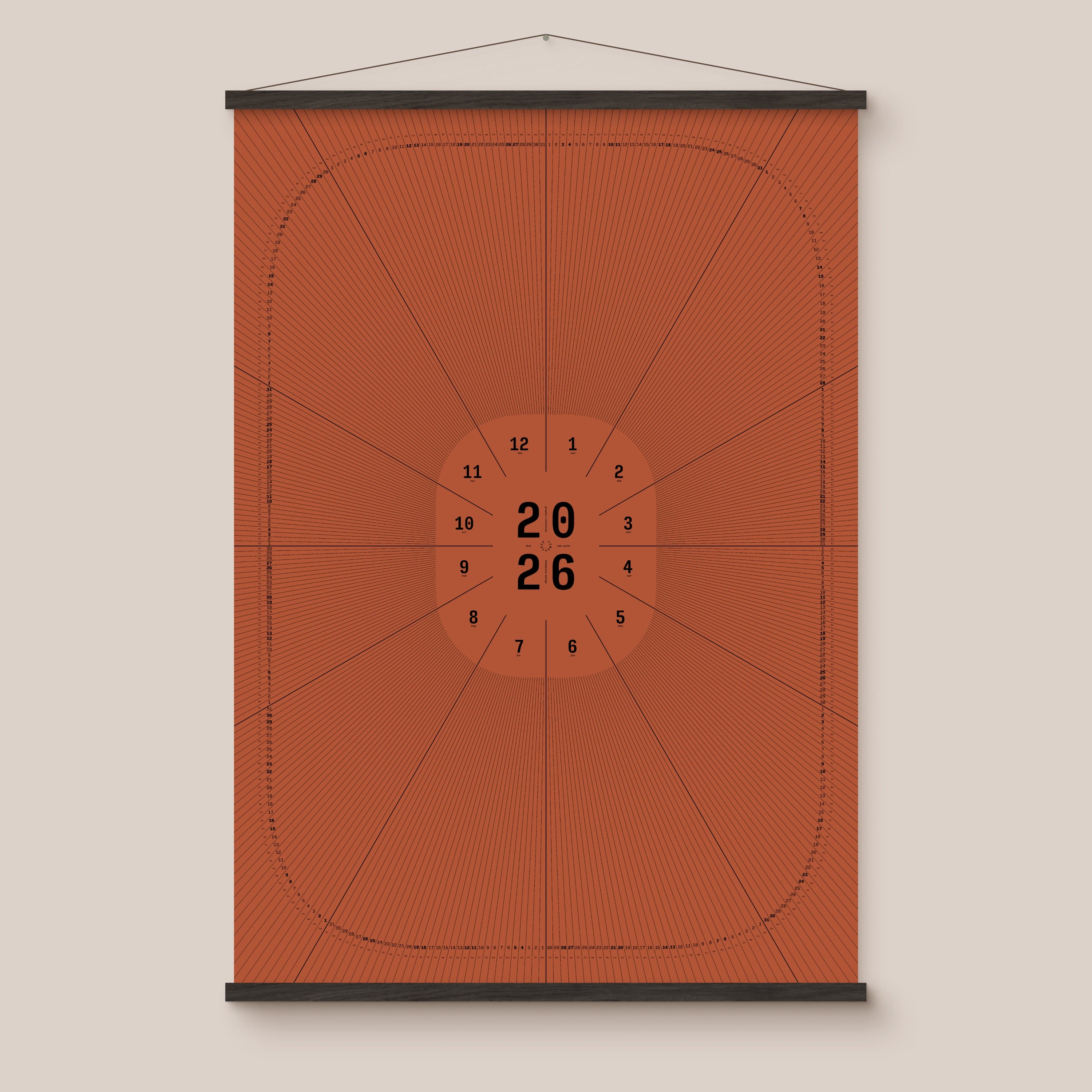 Red geometric calendar with a circular design and numbers on a beige wall, black wooden hanger frame