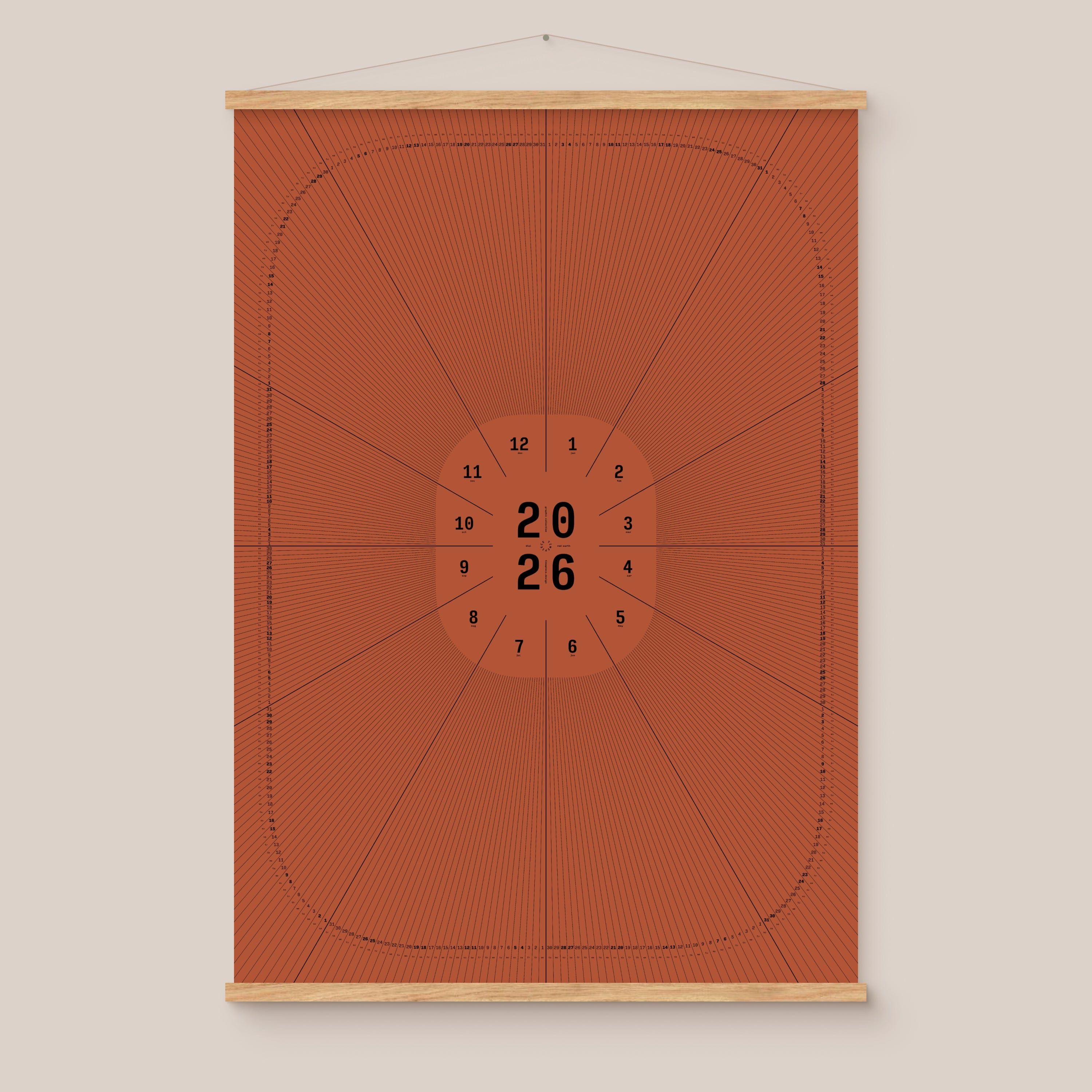 Red geometric calendar with a circular design and numbers on a beige wall, natural wooden hanger frame