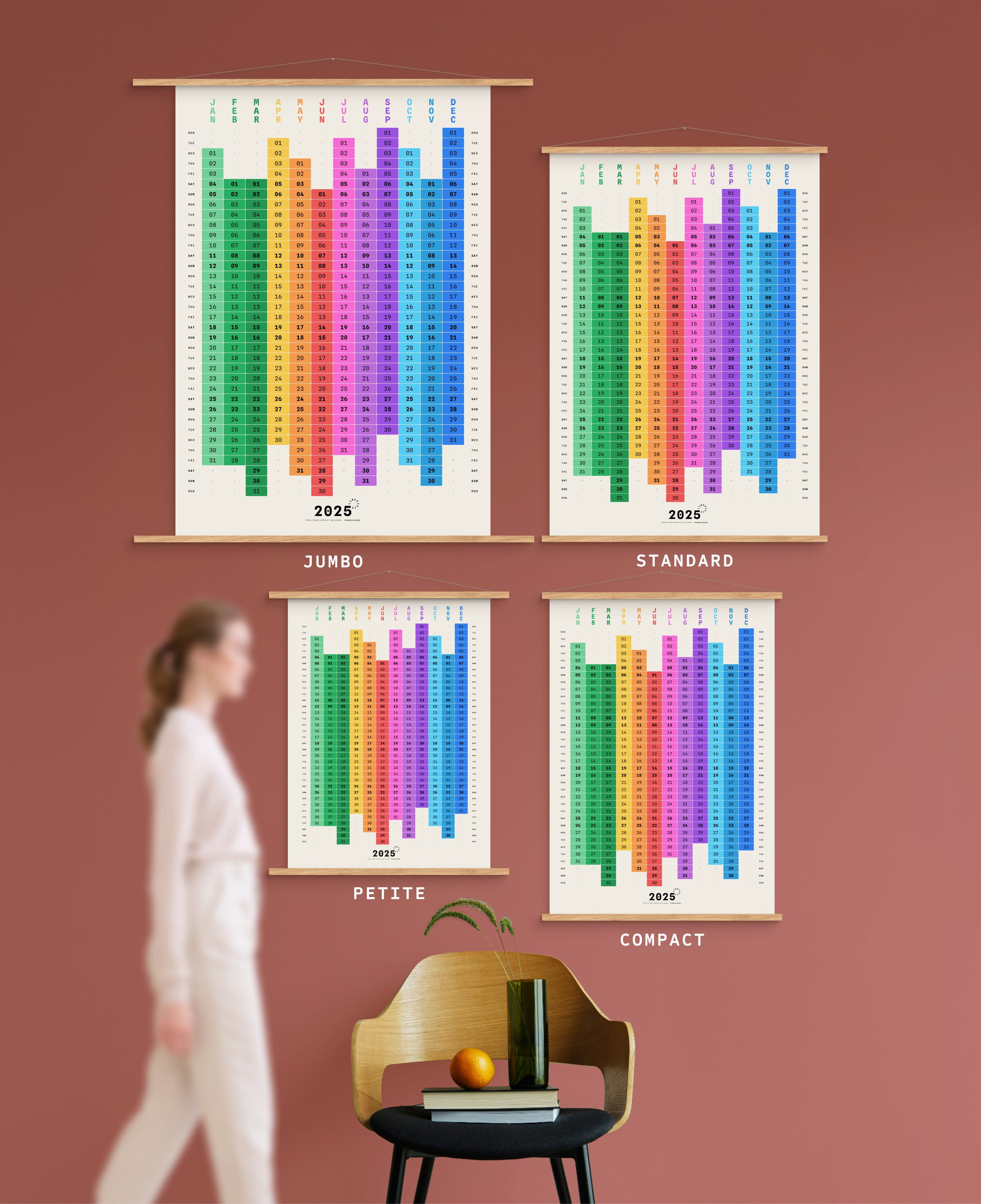 4 sizes of Blocks yearly calendar on green wall, with person, chair, orange and vase shown for scale