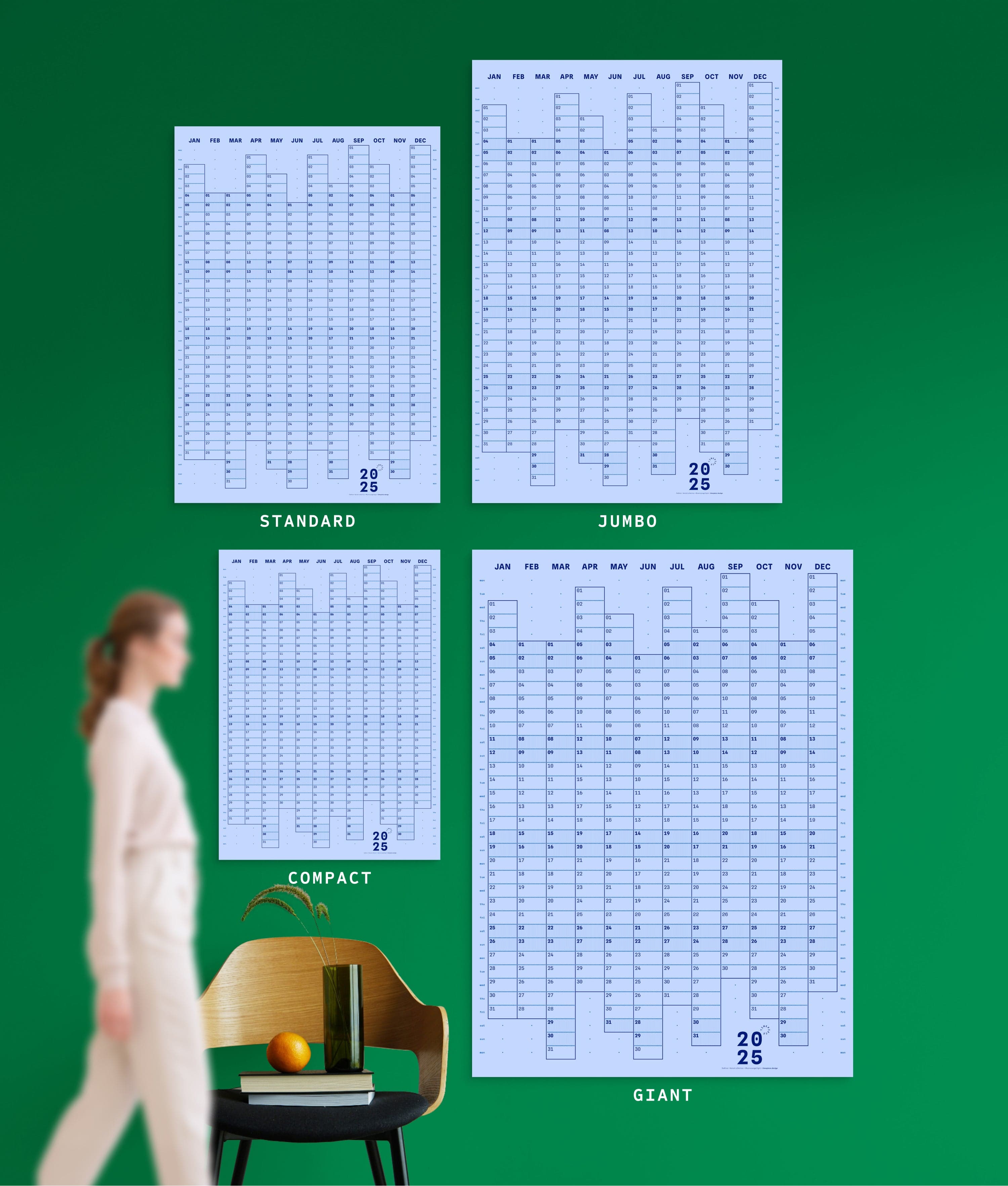 4 sizes of Dotline in Blue colour yearly planner on green wall, with person, chair, orange and vase shown for scale