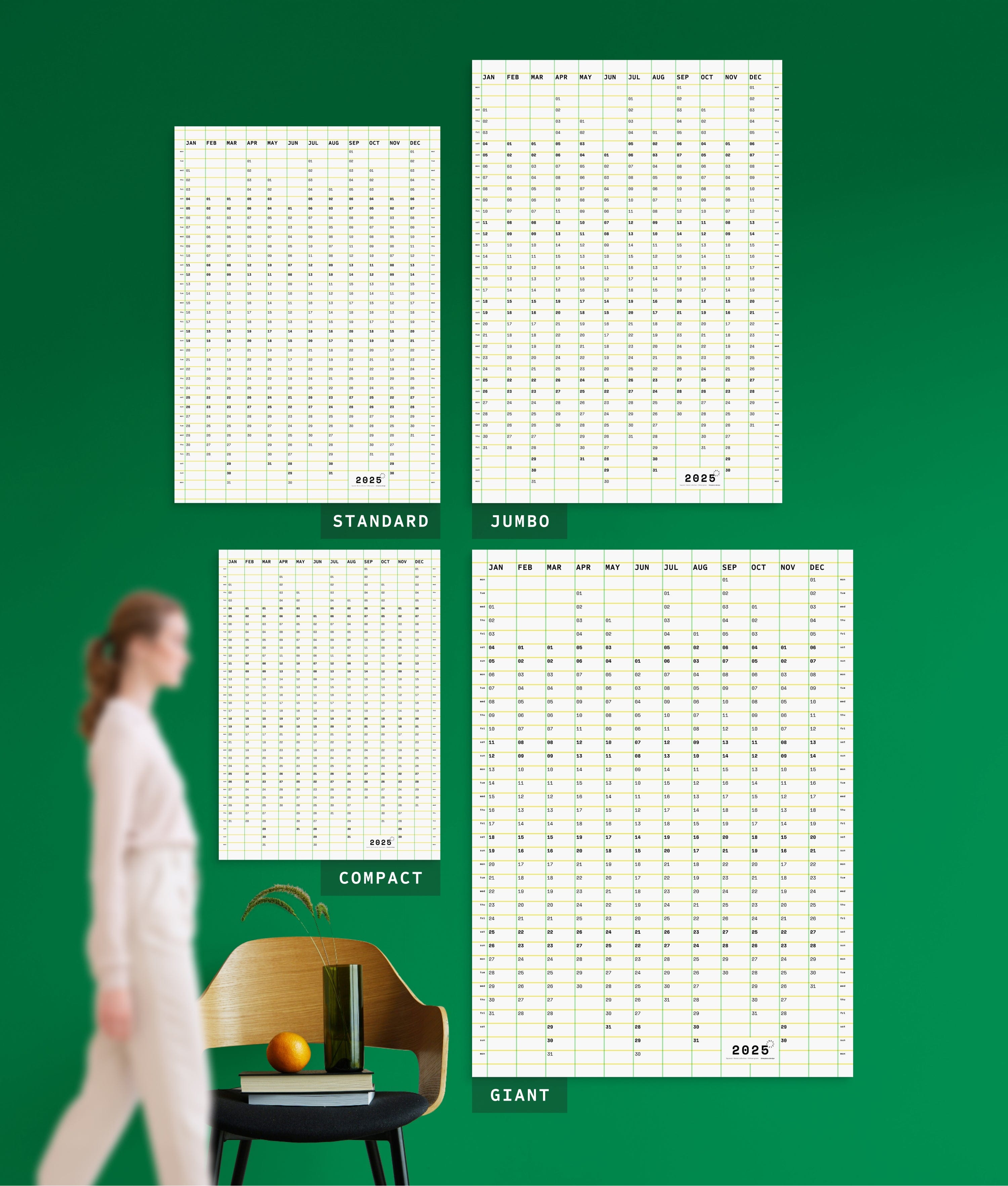 4 sizes of Squared in Green-yellow yearly planner on green wall, with person, chair, orange and vase shown for scale